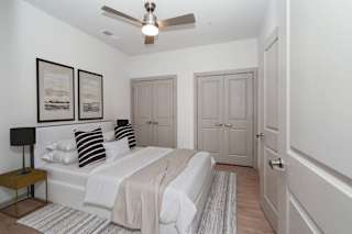 a white bedroom with a bed and a ceiling fan at The Waterford At Rocketts Landing Apartments, PRG Real Estate, Richmond, Virginia