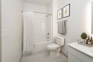 a white bathroom with a shower and a toilet at The Waterford At Rocketts Landing Apartments, PRG Real Estate, Richmond, Virginia