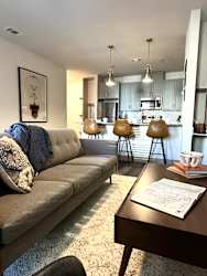 a living room with a couch and a kitchen in the background
