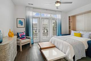 a bedroom with a bed and a sliding glass door at Link Apartments® Mint Street, Charlotte, NC