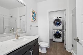 a bathroom with a toilet sink and a washing machine    and a laundry at Link Apartments® Mint Street, Charlotte, NC, 28203