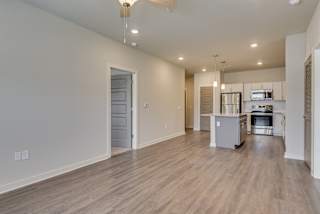 Living area and kitchen with LVT flooring, island and ceiling fan at The Augustan, Augusta
