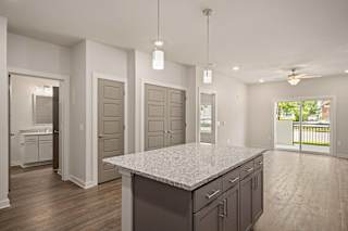 an open kitchen and living room with a granite counter top at The Augustan, Augusta