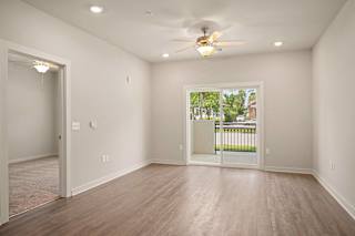 an empty living room with a large window and a ceiling fan at The Augustan, Augusta
