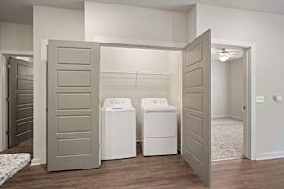 a laundry room with washers and dryers and a closet with open doors at The Augustan, Augusta, Georgia