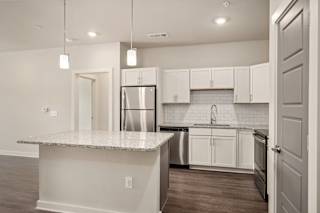 an empty kitchen with white cabinets at The Augustan, Augusta, 30901