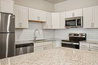 an empty kitchen with granite counter  at The Augustan, Augusta, GA