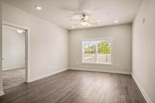 an empty living room with a ceiling fan and a window at The Augustan, Augusta, Georgia