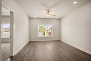 an empty living room with a ceiling fan and a window at The Augustan, Augusta, GA