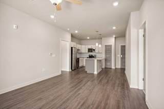 a living room and kitchen with white walls at The Augustan, Augusta
