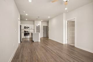 a renovated living room and kitchen with white walls and wood flooring at The Augustan, Georgia, 30901