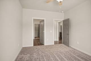 a spacious living room with a carpeted floor and a ceiling fan at The Augustan, Augusta