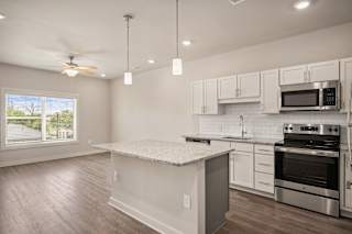 an empty kitchen with an island and appliances at The Augustan, Augusta, Georgia