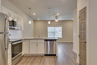 an empty kitchen with an island and stainless steel appliances at The Augustan, Augusta, Georgia