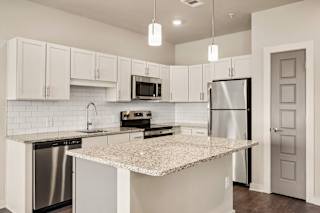 open kitchen with granite counter top and stainless steel appliances at The Augustan, Augusta, 30901