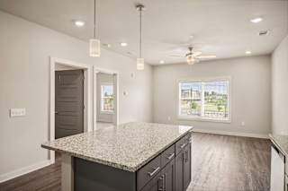 the island in the kitchen of a new home with a granite counter top at The Augustan, Augusta, GA