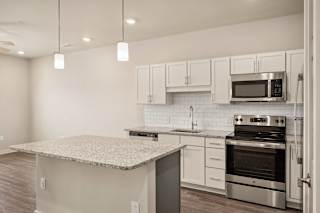 a kitchen with a marble counter top and stainless steel appliances at The Augustan, Augusta, 30901