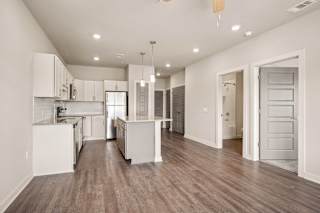 a renovated living room and kitchen with white walls and wood floors at The Augustan, Georgia