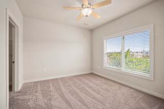 an empty living room with a ceiling fan and a window at The Augustan, Augusta
