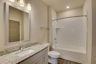a bathroom with a shower toilet and sink and a mirror at The Augustan, Augusta