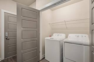 a laundry room with a washer and dryer and a closet with a door at The Augustan, Georgia, 30901