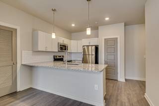 a kitchen with white cabinets and a granite counter top at The Augustan, Augusta, 30901