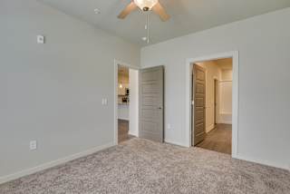 an empty bedroom with a ceiling fan and a door to a hallway at The Augustan, Augusta, Georgia