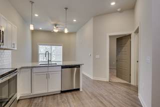 Kitchen space with wood-like flooring and white cabinets at The Augustan, Georgia