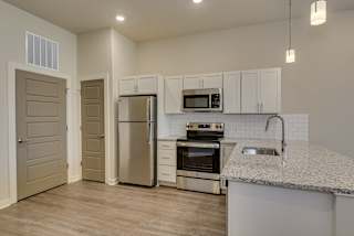 Kitchen with stainless steel appliances and white cabinets at The Augustan, Georgia