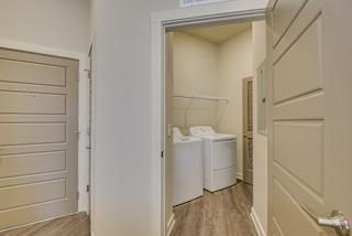 Washer and dryer in laundry closet with wire shelving at The Augustan, Augusta, Georgia