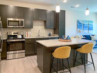 a kitchen with dark cabinets and stainless steel appliances with an island