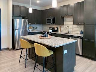a kitchen with stainless steel appliances, granite counter tops, and an island