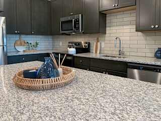 a decorative wicker tray on the granite counter top of the kitchen island