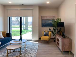 a living room with a couch and a table in front of a wooden tv stand and tv
