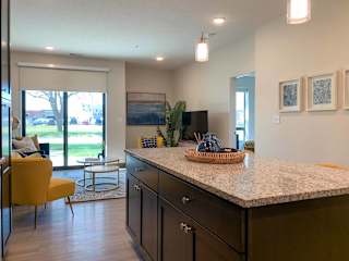 a kitchen island in front of a decorated living room in the backround