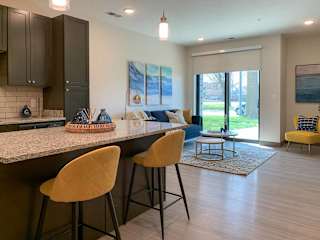 a kitchen with an island with two yellow chairs seated in front of it
