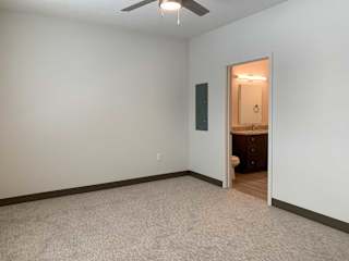 a bedroom with an attached bathroom and ceiling fan