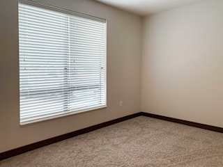 a carpeted bedroom with a large window