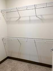 a walk in closet with empty shelves