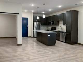 a kitchen with dark cabinets and light granite countertops
