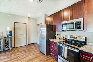 A kitchen with wooden cabinets and a stainless steel refrigerator.