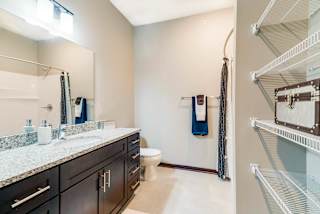 A bathroom with a marble countertop and a walk-in shower.