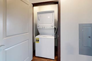 A stacked full size washer and dryer in a closet.