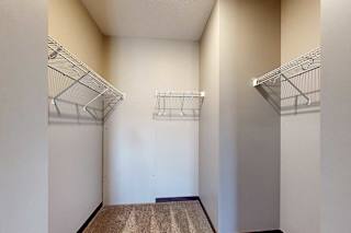 An oversized walk-in closet with built-in wire shelves for storage.