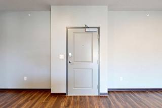 A light grey front door to the apartment with a slight bump in for the hallway recess.