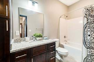 a bathroom with a large mirror and a toilet and a shower