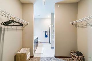 a walk in closet in an apartment with a shoe rack and a laundry room