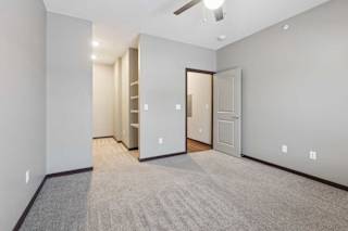 A carpeted bedroom with an open walk-in closet.