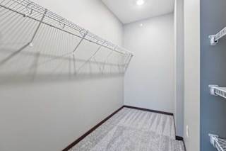 An oversized walk-in closet with several built-in wire shelves.