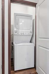 A stacked full-sized washer and dryer in a laundry room.